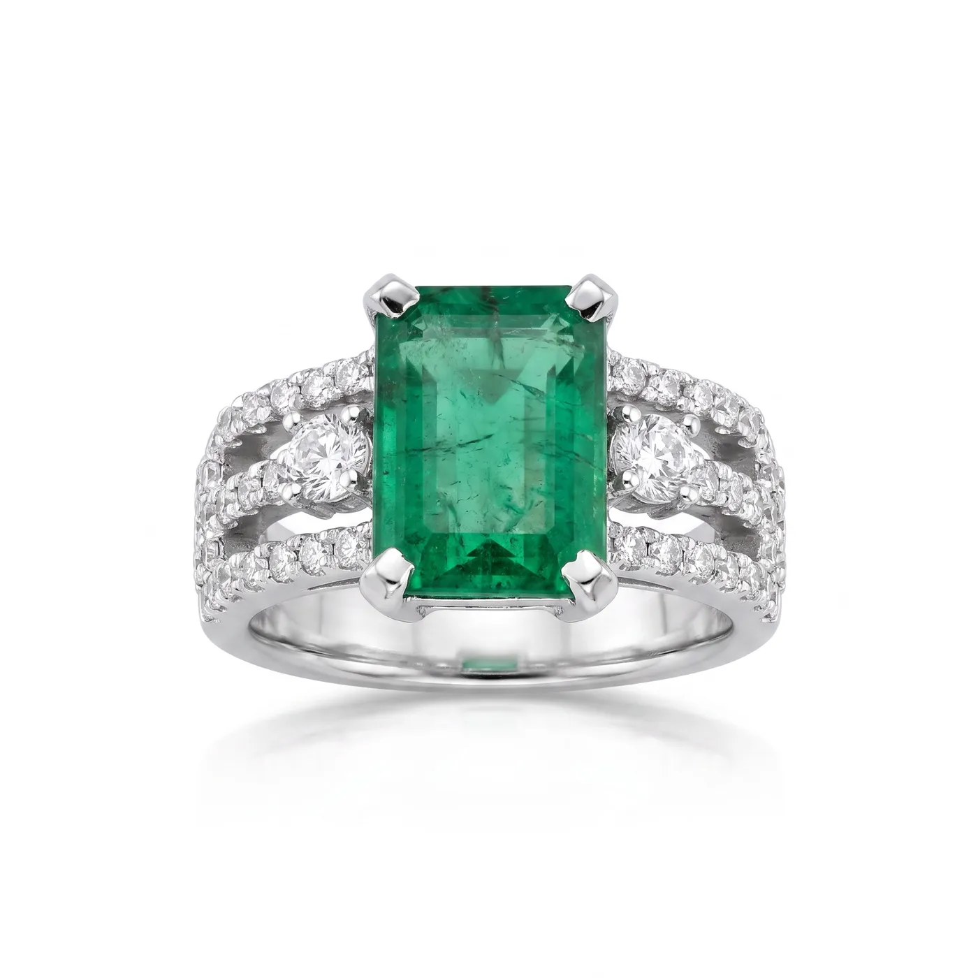 Anillo con esmeralda talla esmeralda enmarcada por dos bandas de diamantes sobre oro blanco.